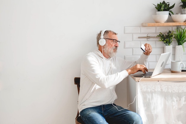 Senior oudere man op laptop die met creditcard betaalt voor online winkelen, kopieerruimte en plaats voor reclame