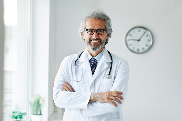 Senior ouderen grijs haar actieve dokter ziekenhuis medische geneeskunde gezondheidszorg kliniek kantoor portret bril man stethoscoop specialist