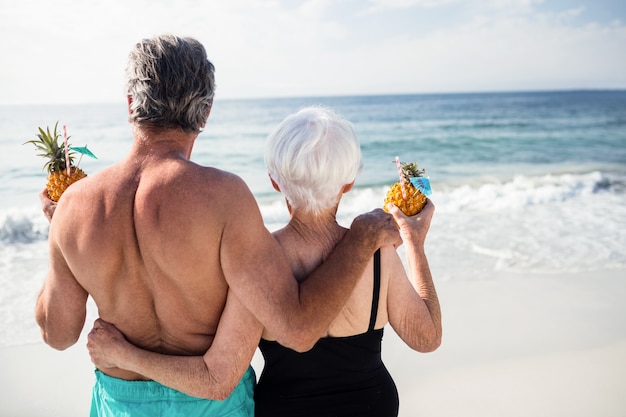 Senior paar bedrijf ananas cocktail op strand