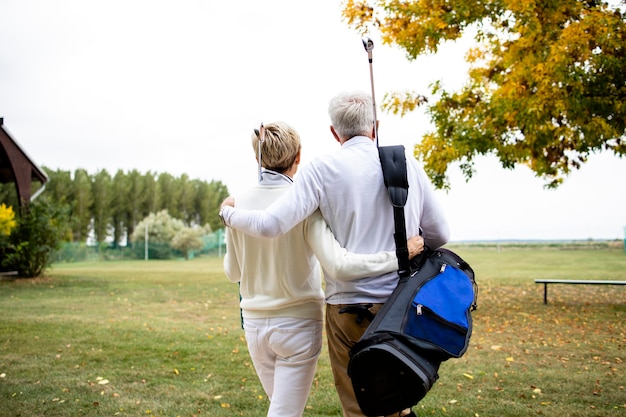 Senior paar bij elkaar te houden en te genieten van recreatieve tijd in pensionering door golf te spelen.