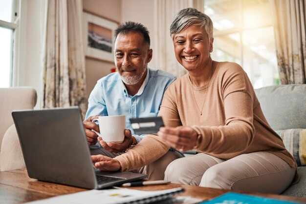 Senior paar creditcard en laptop voor thuis online winkelen betaling en fintech sparen of lenen gelukkige oudere vrouw en man met debetbankieren investeringen en financiën of e-commerce op computer