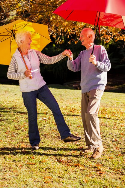 Senior paar dansen met parasols