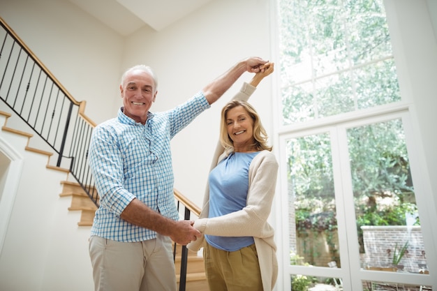 Senior paar dansen samen in de woonkamer