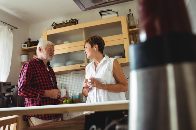 Senior paar interactie terwijl het hebben van koffie