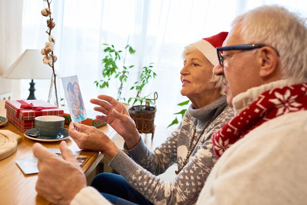 Foto senior paar kijken naar foto's op kerstmis