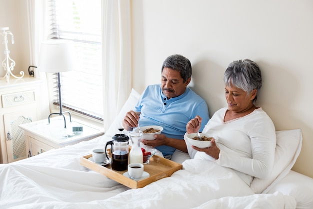 Senior paar ontbijten in de slaapkamer