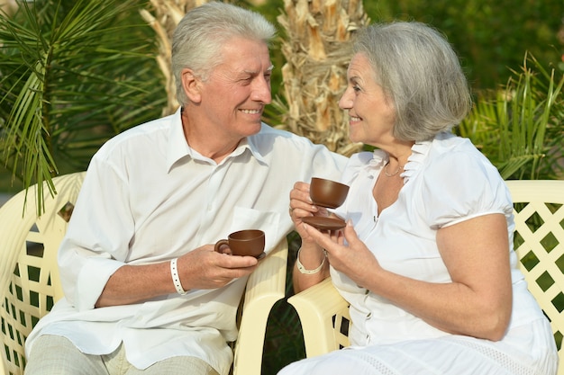 Senior paar rusten in het resort tijdens vakantie met kopjes thee