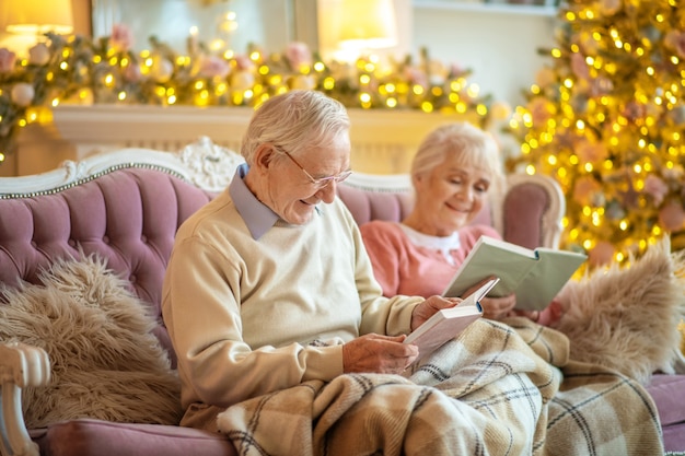 Senior paar zittend op een bank en het lezen van boeken