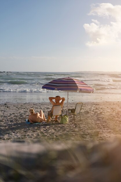 Foto senior paar zittend op het strand volledig schot