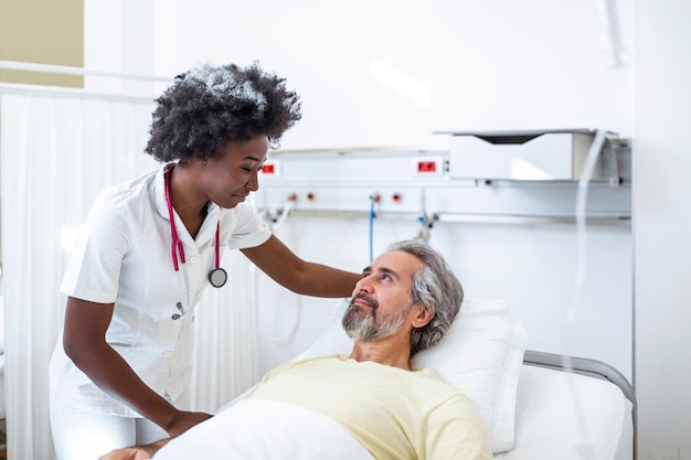 Senior patient on bed talking to female doctor in hospital room