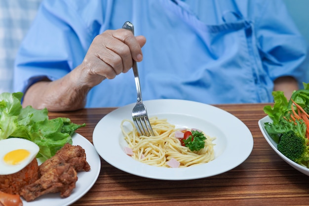 病院で朝食を食べるシニアの患者