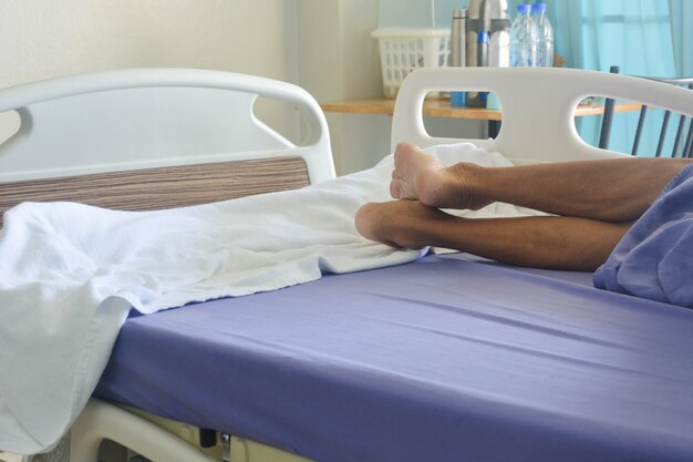 Senior patient lying on the bed in the patient room at the hospital