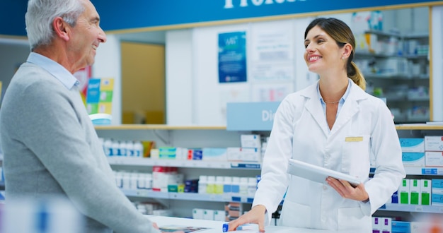 senior patient tablet and happy woman pharmacist or clerk helping clinic customer healthcare client or person medicine shop pharmacy advice and chemist search online database for store product