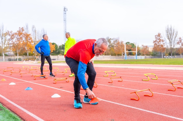 ランニングトラックでトレーニング要素を準備する高齢者