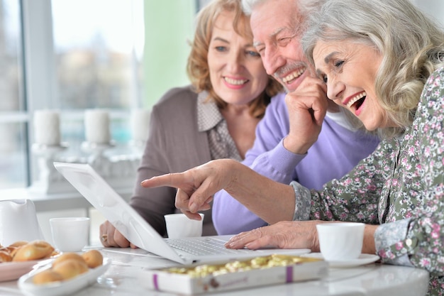 Senior people with laptop drinking tea