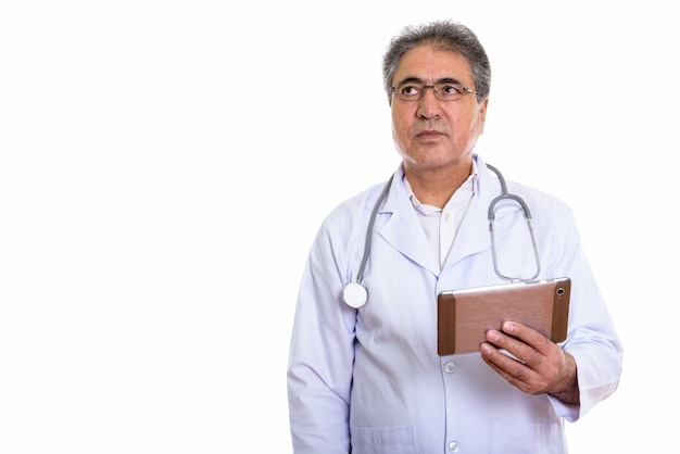 senior Persian man doctor holding digital tablet and looking at copyspace