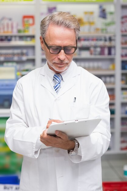 Senior pharmacist holding clipboard