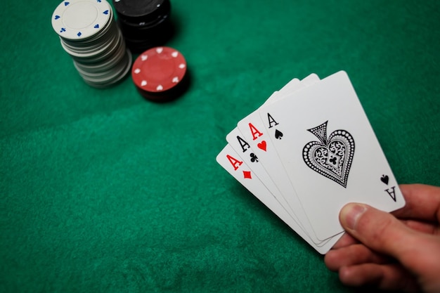 Senior poker. De speler heeft in zijn hand vier speelkaarten, vier azen. Casino tafel achtergrond