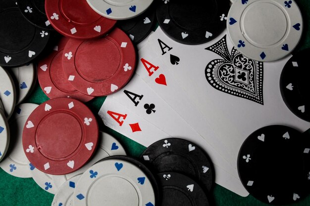 Photo senior poker. four playing cards, four aces and poker chips on a green casino table.