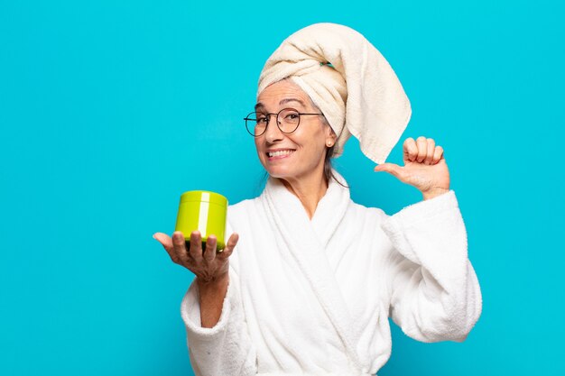 Senior pretty woman after shower wearing bathrobe. facial cleaning or shower products concept