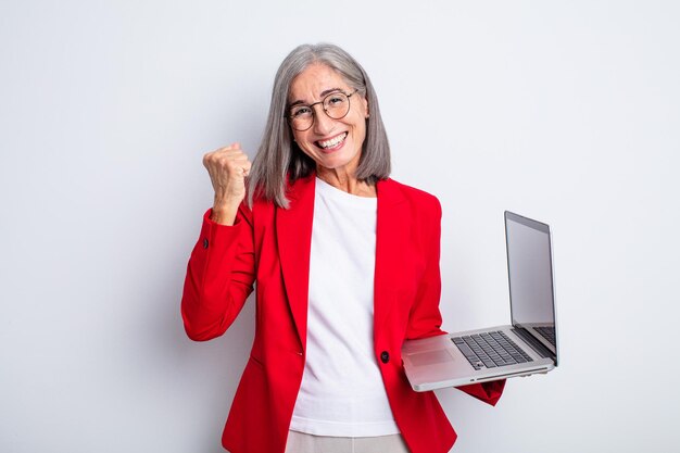 Senior pretty woman feeling shocked,laughing and celebrating success. business and laptop concept