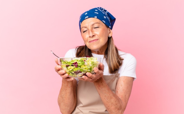 Donna graziosa anziana che prepara un'insalata