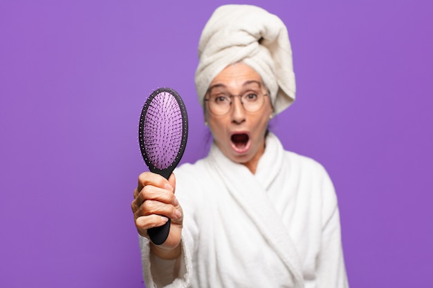 ヘアブラシを持つ年配のきれいな女性