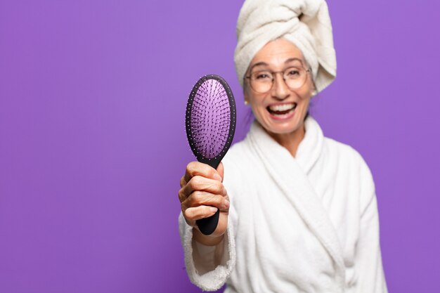 ヘアブラシを持つ年配のきれいな女性