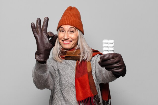 Photo senior pretty woman with a pills tablet wearing winter clothes