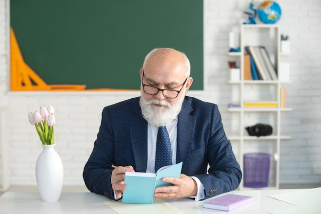 Senior professor op school Man leraar met baard in de klas