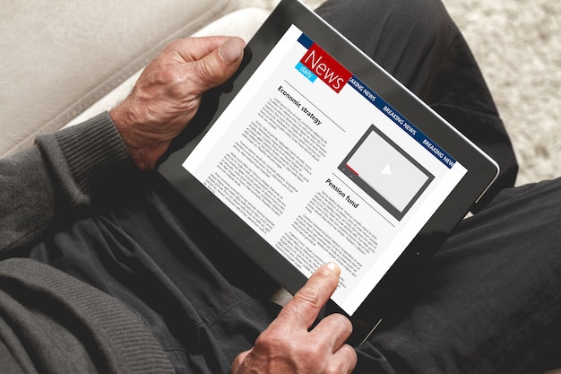 Senior reading news on tablet