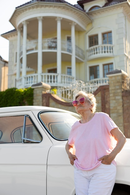 Senior reiziger staand nest aan haar auto