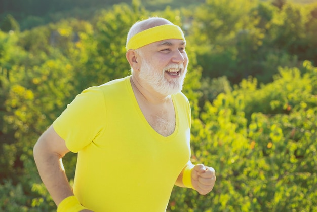 Старший спортсмен бегает на свежем воздухе и наслаждается солнечным днем Старший мужчина занимается спортом на открытом воздухе Старший мужчина путешествует пешком летом на природе
