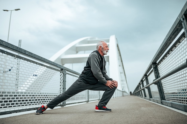 Senior sportsman warming-up before a run.