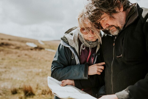 Senior toeristenpaar kijkt naar de kaart terwijl ze verdwaald zijn in Wales, VK