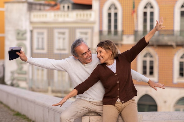 Senior tourists couple posing spreading hands like flying airplane outdoors