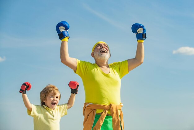 Senior trainer en kleine jongen met bokshandschoenen grappig schattig kind vechten tegen de beste cardiotraining ac...