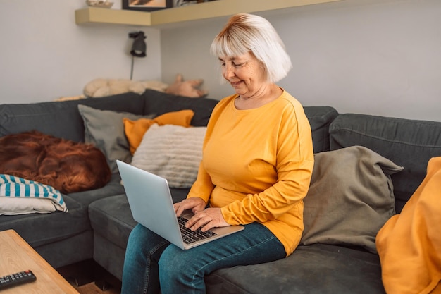 Senior volwassen oudere vrouw kijken naar zakelijke training online webinar op laptopcomputer op afstand werken