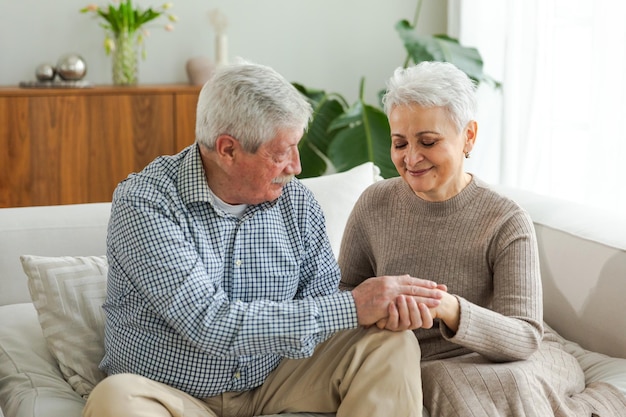 Senior volwassen volwassen koppel in de liefde hand in hand thuis middelbare leeftijd oude man en vrouw op zoek met