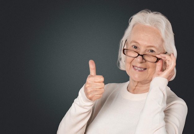 Senior volwassene, grootmoeder lacht en toont duim omhoog teken