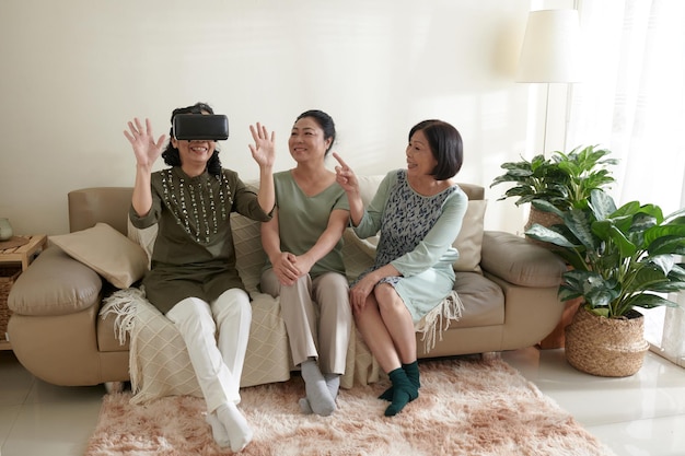 Senior vrienden enthousiast om videogame te spelen in virtual reality-headset