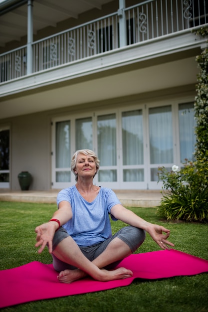 Senior vrouw beoefenen van yoga op Trainingsmat