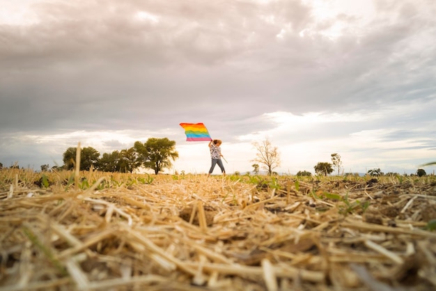 Senior vrouw die buiten met regenboogvlag loopt