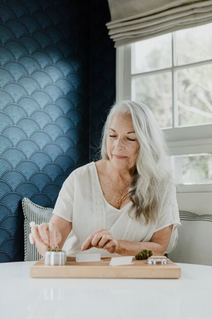 Senior vrouw die een joint rolt