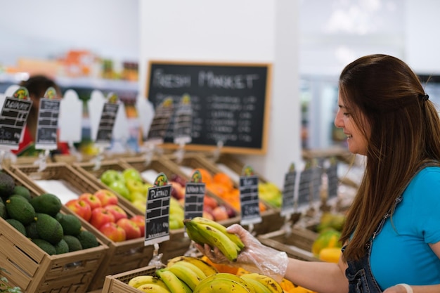 Senior vrouw die fruit op de markt kiest