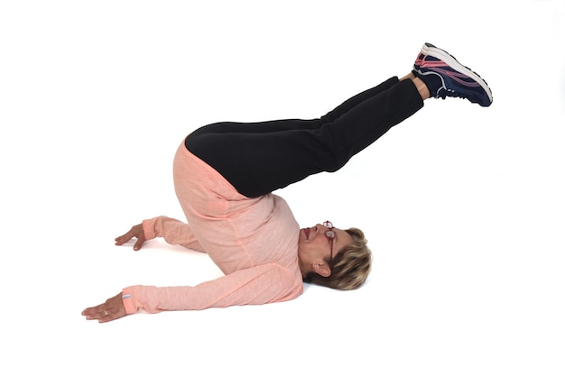 Foto senior vrouw die op de vloer traint op een witte achtergrond