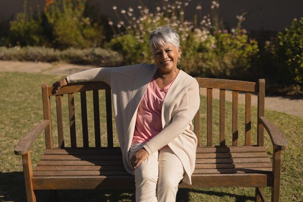 Foto senior vrouw die op een bankje in het park zit