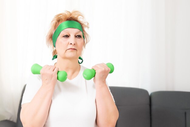 Senior vrouw doet fysieke oefeningen met een halter.