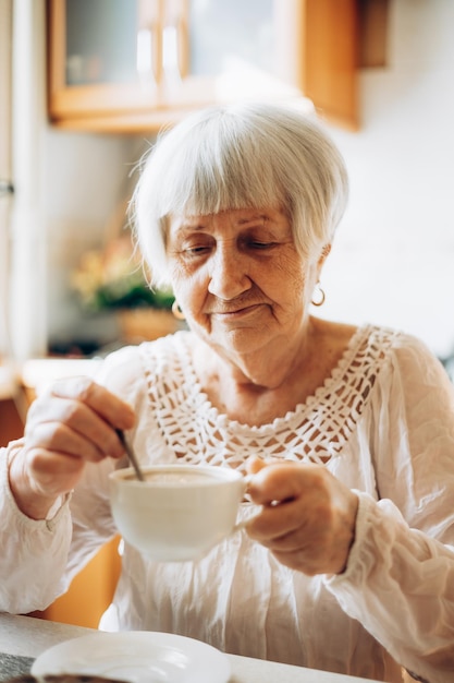 Senior vrouw genieten van kopje thee thuis