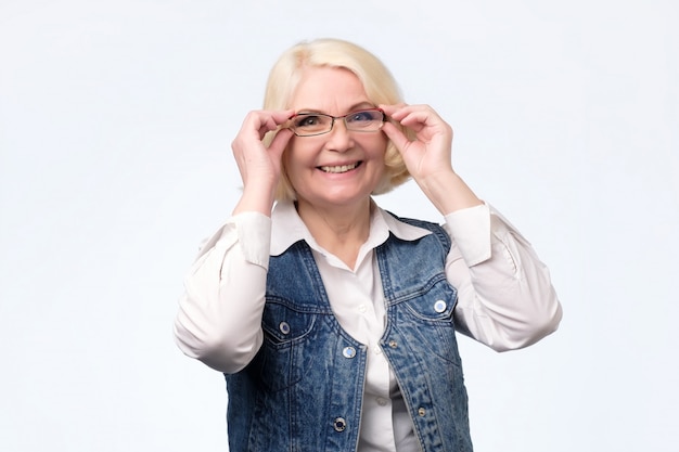 Senior vrouw glazen aanpassen en glimlachen